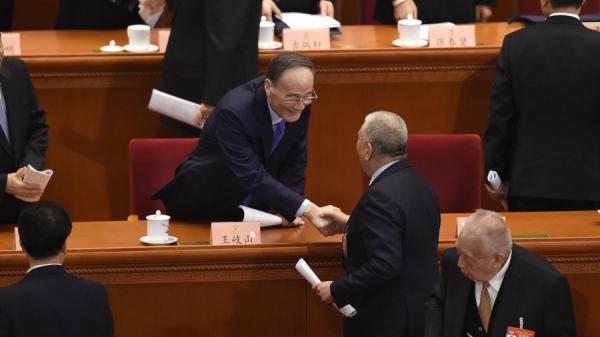2019年3月中共两会,王岐山和与会者握手,右下为前香港特首董建华。