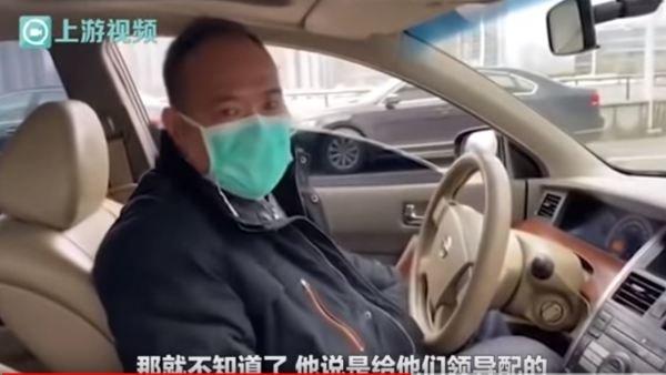 从红会提一箱口罩放进公务车的男子。(图片来源:视频截图)