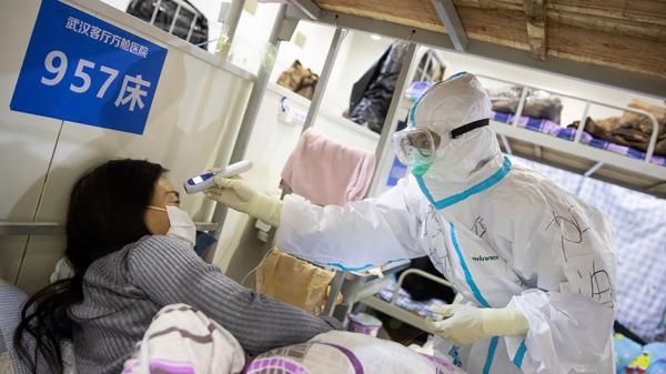 武汉市方舱医院的医生在检查患者。(Getty Images)