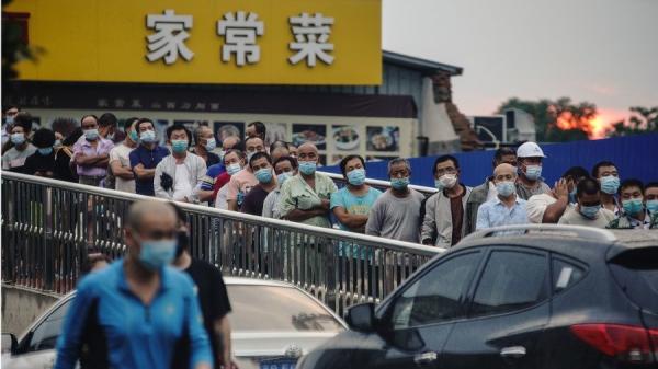 6月18日,大批市民几乎肩并肩的排队等候核酸检测。(图片来源:Photo by Lintao Zhang/Getty Images)