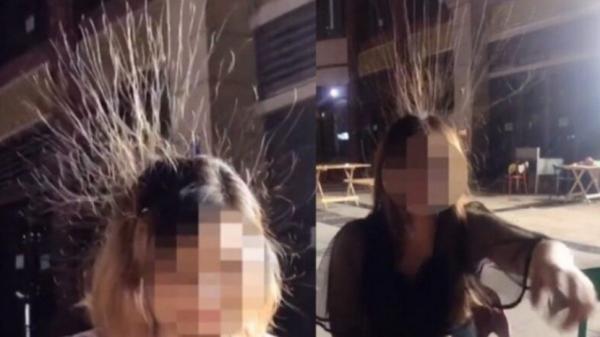 四川两名女子在露天座位吃宵夜时,两人的长发犹如被静电吸引,一根根竖了起来,专家称情况很危险。(视频截图)
