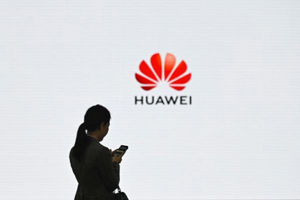 在中国广东省深圳市的华为数字化转型展示活动上,华为的一名员工在使用她的手机。(WANG ZHAO/AFP via Getty Images)