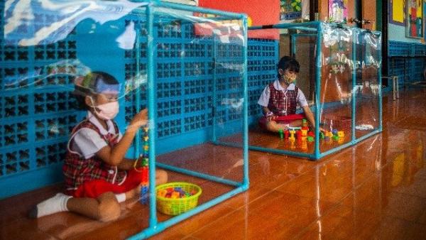 孩子在塑料框里独自玩玩具(图片来源:Lauren DeCicca/Getty Images)