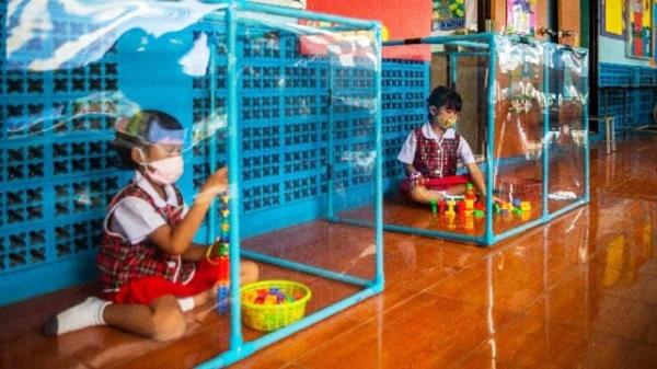 孩子在塑料框里独自玩玩具。(Lauren DeCicca/Getty Images)