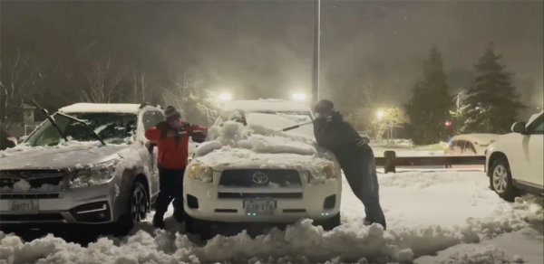 克瑞斯丁(左)和安碧为刚下班的医务人员清理车窗上的积雪。(视频截图)