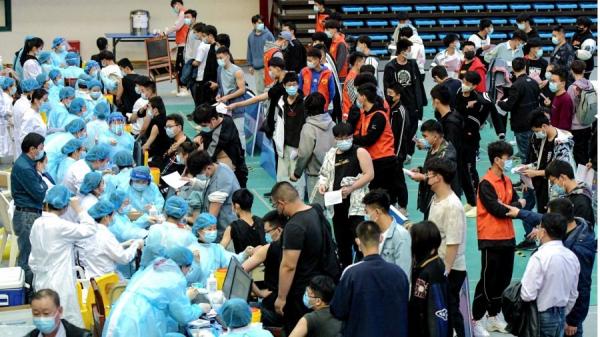 这张摄于2021年3月30日的照片显示,大学生正在山东省青岛市的一所大学排队接种疫苗。(图片来源:STR/AFP via Getty Imges)