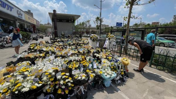 郑州市一名男子在地铁站前献花以纪念被洪水夺去生命的灾民。(图片来源:Getty Images)