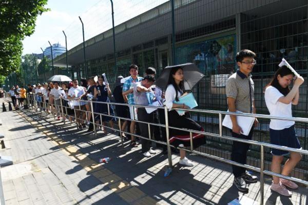 中国民众在美国驻华大使馆外等待签证。(GREG BAKER/AFP/Getty Images)