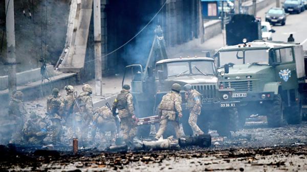 基辅郊区战场,乌克兰士兵在击退俄罗斯进攻后,正在收集未爆炸的炮弹。(SERGEI SUPINSKY/AF/Getty Images)