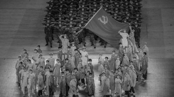 2021年6月28日,在北京鸟巢体育场举行的庆祝共产党成立 100 周年的晚会上,扮成医务人员的表演者高举着共产党党旗。(图片来源:Kevin Frayer/Getty Images)