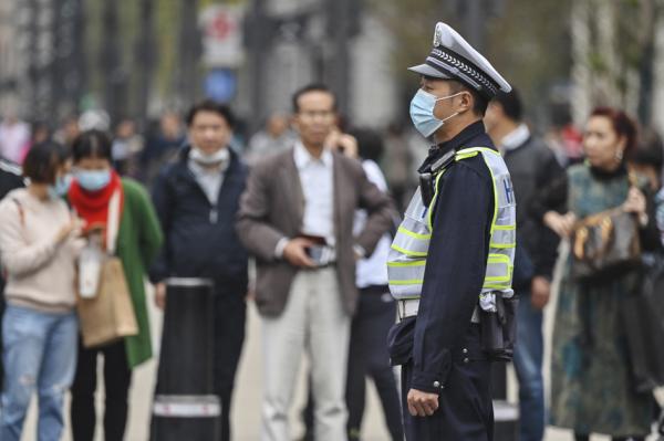 2020年10月28日,上海一名戴口罩的警察在监视街道上的行人。(HECTOR RETAMAL/AFP via Getty Images)