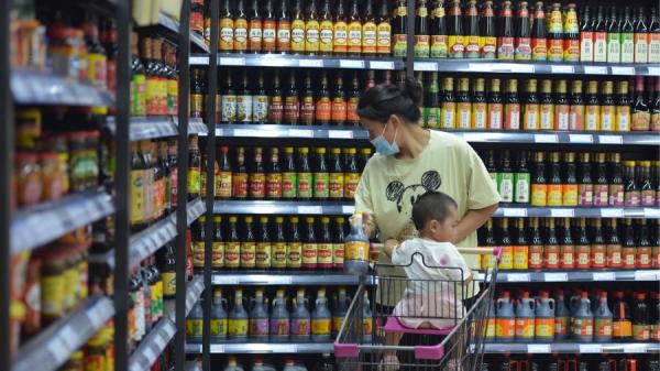 一名妇女带着孩子在超市购物。(图片来源:STR/AFP/Getty Images)
