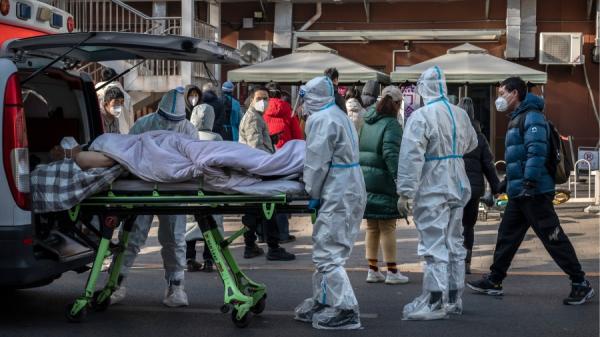 北京大量发烧病人在医院外排队候医,有重病人被从救护车上抬下。(图片来源:Getty Images)