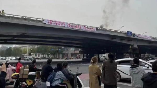 北京四通桥一名男子挂横幅抗议,遭到中共封杀。 (图片来源:网络截图)