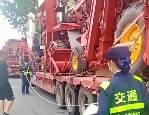 当地交警拿出皮尺一一测量这些装载收割机的卡车。(图片来源:微博)