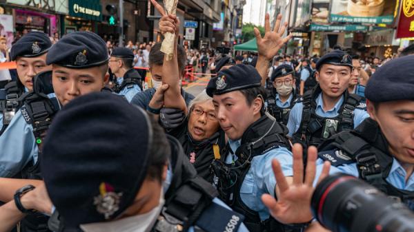 王婆婆手持鲜花到铜锣湾,随即被警方带上警车。(图片来源:Getty Images)