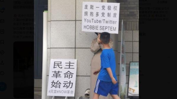 北京大学家园食堂门前有人举牌“罢黜一党极权,拥抱多党制”示威。(图片来源:网路截图)
