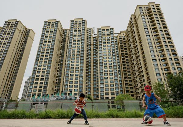 2022年7月28日,孩子们在房地产商恒大在北京开发的一个住宅区前玩耍。(NOEL CELIS/AFP via Getty Images)
