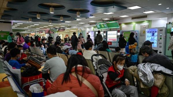2023 年 11 月 23 日,儿童和他们的父母在北京一家儿童医院的门诊区等候。(图片来源:Getty Images)