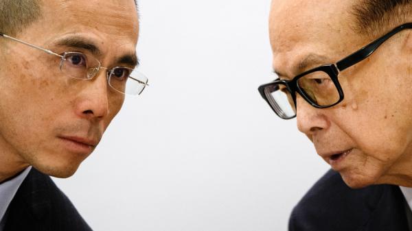 图为2018年,香港首富李嘉诚(右)与长子长实主席李泽钜(左)出席记者会。(图片来源:Getty Images)