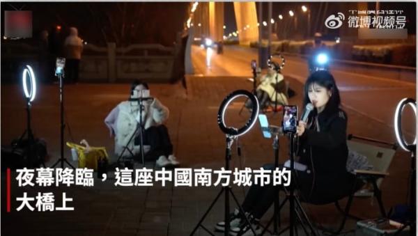 夜幕下的广西桂林网红正在一座大桥上直播。(图片来源:微博截图)