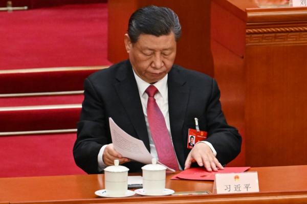习近平在中共全国人大闭幕式上收起文件。