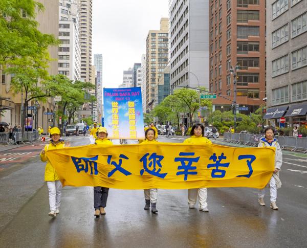 参加游行的法轮功学员拉着横幅 “ 师父您辛苦了 ”, 表达对师父感恩。(摄影:Leo/看中国)