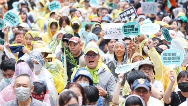 关切国会职权修法,5月24日,台湾民众于立院外穿雨衣抗议。(图片来源:中央社)