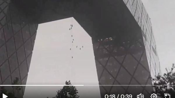 北京10级大风,央视大楼外10多名高空作业工人随风惊险飘荡。(图片来源:视频截图)