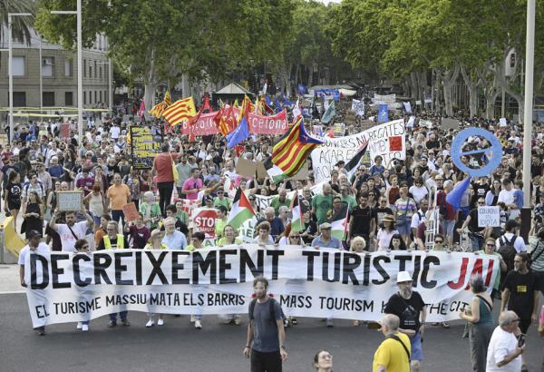 7月6日,巴塞罗那示威者举着“减少旅游业”的标语,上街游行。(JOSEP LAGO/AFP via Getty Images)