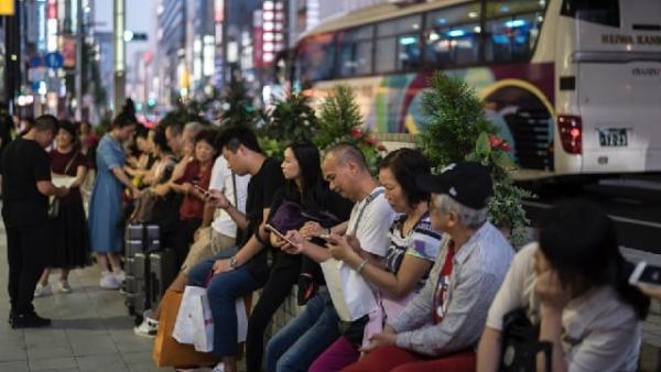 2019年10月2日,中国游客在日本东京银座购物区等待旅游巴士。(图片来源:Getty Images)