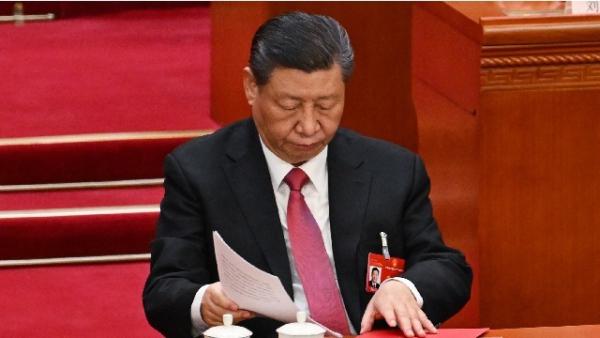 图为2024年3月11日,习近平在北京人民大会堂举行的第十四届全国人民代表大会闭幕会议上收起文件。