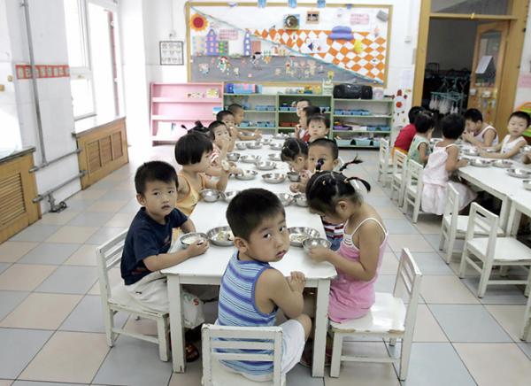 2004年8月5日,北京一家幼儿园学生在享用早餐。(Getty Images)