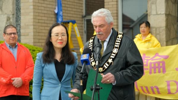 2025年5月6日,加拿大安省阿默斯特堡市(Amherstburg)市长迈克尔.普鲁(右)(Michael Prue)在庆祝第33届世界法轮大法日升旗仪式上发言。(图片来源:NTD)