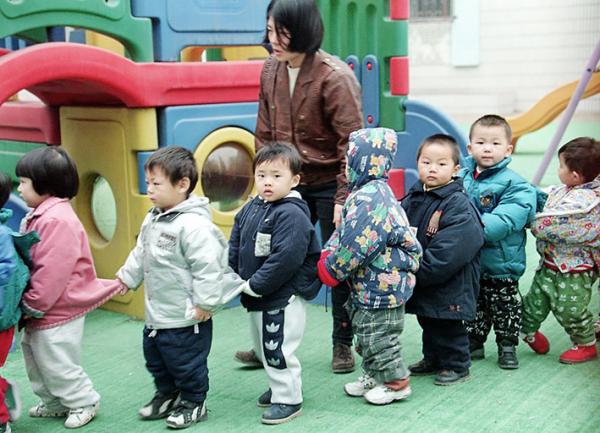 中国北京一所幼儿园的儿童在老师的带领下排队。(GOH CHAI HIN/AFP via Getty Images)