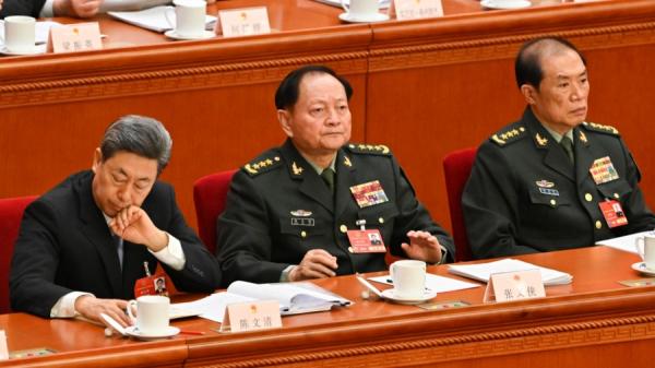 2025年3月5日，军委副主席张又侠（中）、何卫东（右）出席在北京人民大会堂举行的全国人民代表大会开幕会议。（图片来源：ADEK BERRY/AFP via Getty Images）