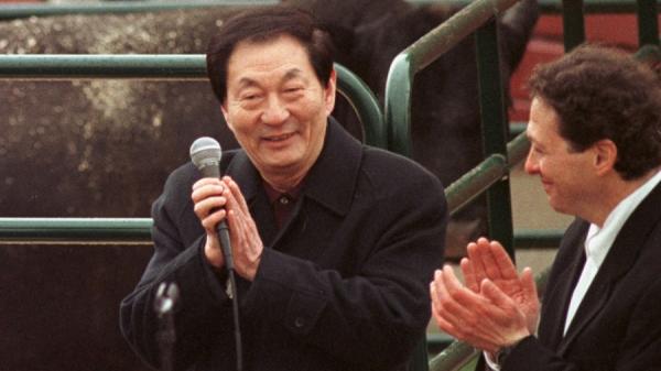 1999年4月11日,中国国务院总理朱镕基(左)在伊利诺伊州利伯蒂维尔的马雷尔巴农场向农民发表讲话时与汤姆·普利兹克一起鼓掌。(图片来源:TANNEN MAURY/AFP via Getty Images)