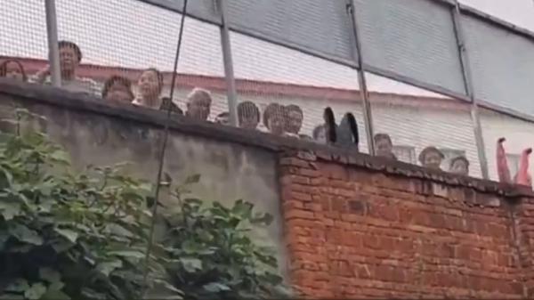 重庆一精神病院多名“病人”在围墙内向路人求救。（图片来源：网路截图）