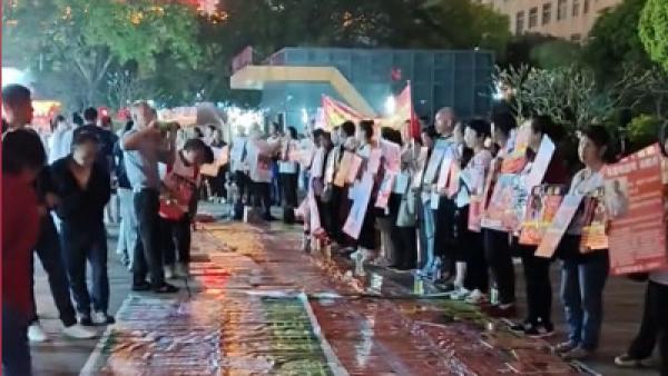 中国大陆失亲家属在街头举牌寻找失踪的家人。（图片来源：视频截图）