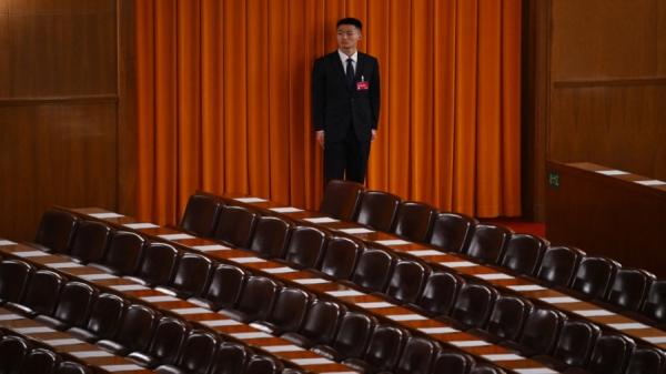 2024年3月10日，北京人民大会堂，中国人民政治协商会议闭幕前，一名安保人员在看守代表席。（图片来源：GREG BAKER/AFP via Getty Images）