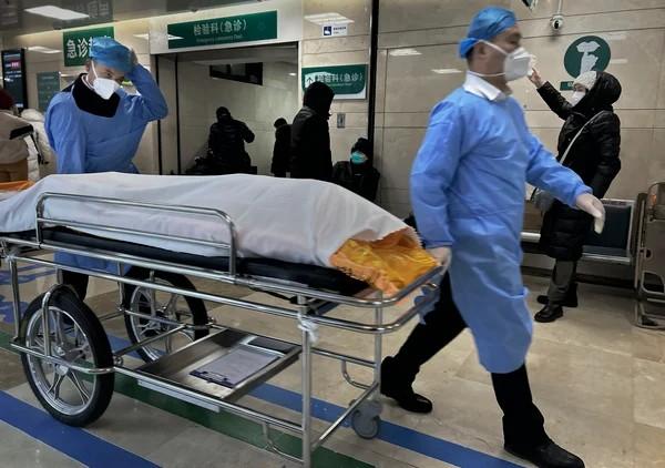 2023年1月2日，在中国北京一家医院繁忙的急诊室里，医护人员用担架推着一具遗体。（图片来源：Getty Images）