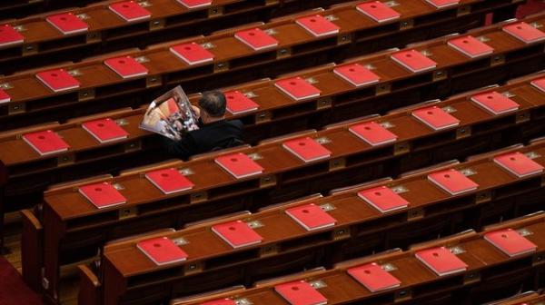 2026年3月12日，在全中共国人民代表大会闭幕式前，一名代表正在北京人民大会堂里阅读关于会议的杂志。（图片来源：Kevin Frayer/Getty Images）