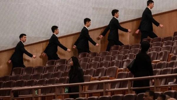 2026年3月12日,中共全国人民代表大会闭幕式开始前,在北京人民大会堂的安保人员走向各自岗位。(图片来源:Kevin Frayer/Getty Images)