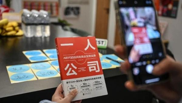 2026年4月12日,一人公司SoloNest的创始人戴凯伦(Karen Dai)在上海的一间会议室里为她的新书《一人公司》(One Person Company)拍照。许多中国年轻人担心35岁以后会在职场上遭遇年龄歧视,因此越来越多地创办“一人公司”,让人工智能承担大部分工作。(图片来源:Jade GAO/AFP via Getty Images)
