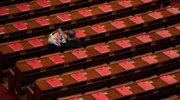 2026年3月12日,在全中共国人民代表大会闭幕式前,一名代表正在北京人民大会堂里阅读关于会议的杂志。(图片来源:Kevin Frayer/Getty Images)