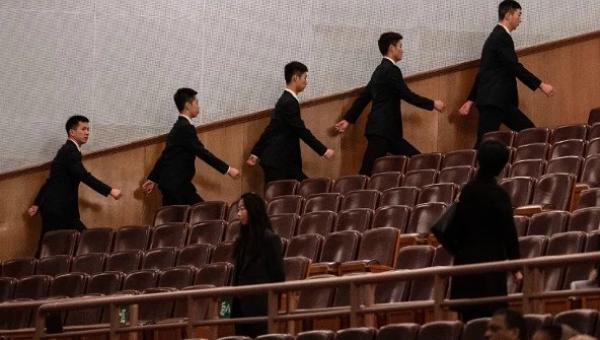 2026年3月12日,中共全国人民代表大会闭幕式开始前,在北京人民大会堂的安保人员走向各自岗位。(图片来源:Kevin Frayer/Getty Images)