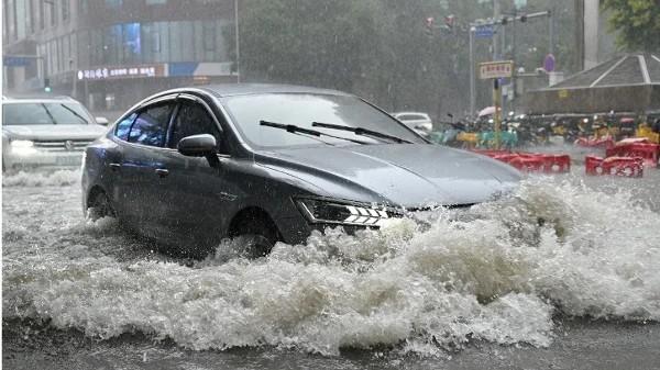 2026年7月7日,一辆汽车行驶在北京一条被洪水淹没的街道上。(图片来源:Adek BERRY / AFP via Getty Images)