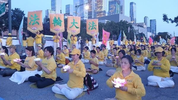 在反迫害27周年集会上，法轮功学员手举莲花，悼念被中共迫害致死的法轮功学员。（摄影：Daniel/看中国）