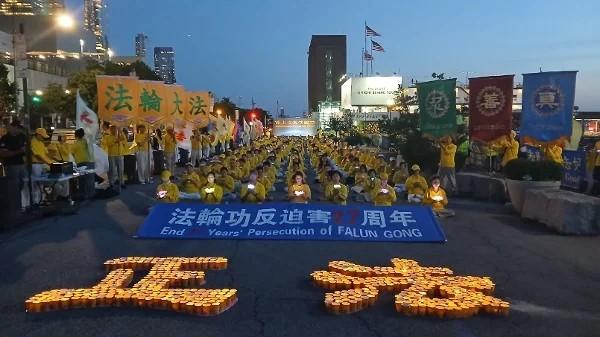 在反迫害27周年集会上，法轮功学员手举莲花，悼念被中共迫害致死的法轮功学员。（摄影/看中国/Daniel）