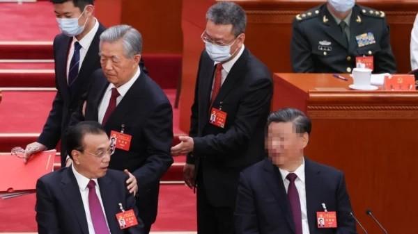 2022年10月22日,在北京人民大会堂举行的中共第二十次全国代表大会闭幕式上,前中共党魁胡锦涛(中)被架离会场。(图片来源:Lintao Zhang/Getty Images)